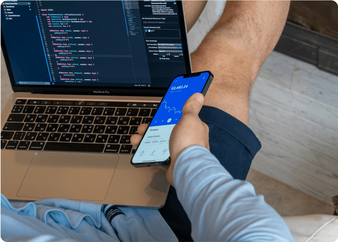 Someone holding a phone and laptop